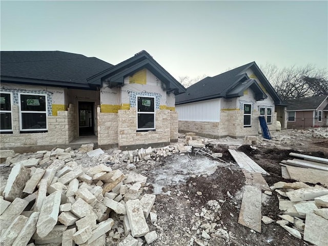 view of front of property with stone siding and a shingled roof