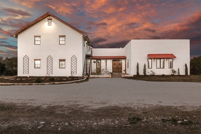 view of front of home featuring stucco siding and stairs