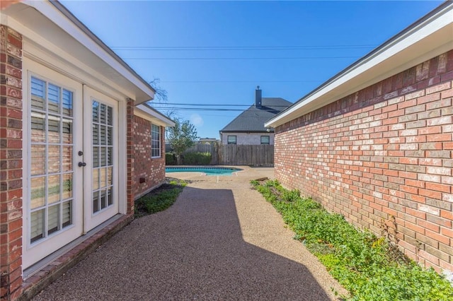 view of patio / terrace with a fenced in pool and french doors