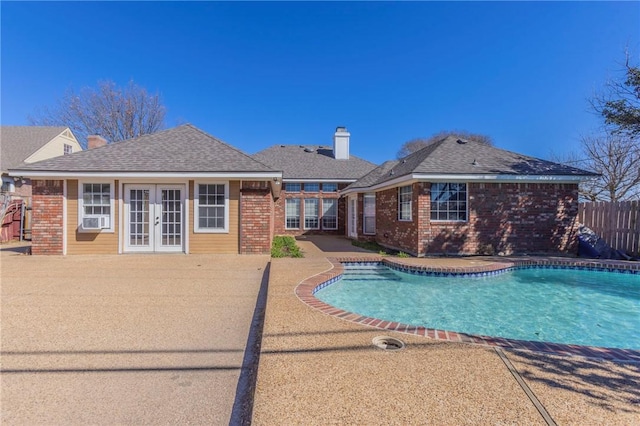 view of pool with cooling unit, a patio area, and french doors