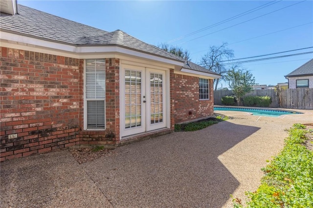 doorway to property featuring a fenced in pool, a patio area, and french doors