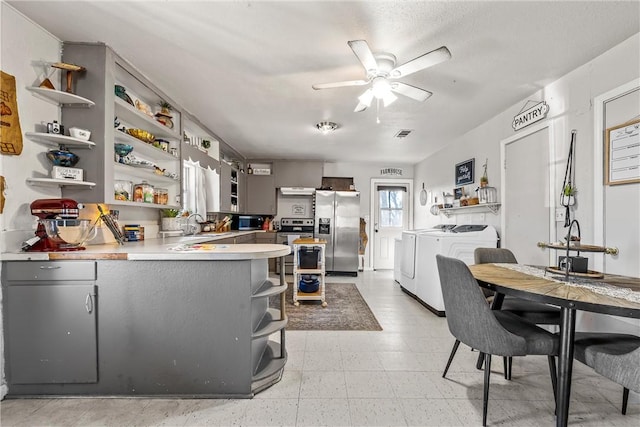 kitchen featuring gray cabinets, ceiling fan, stainless steel appliances, washing machine and clothes dryer, and kitchen peninsula