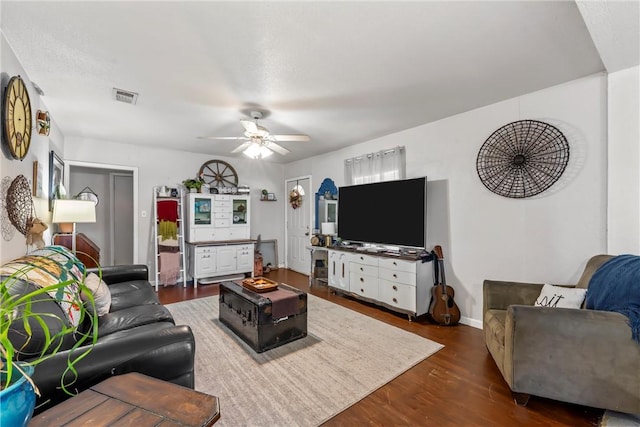 living room featuring dark wood-type flooring and ceiling fan