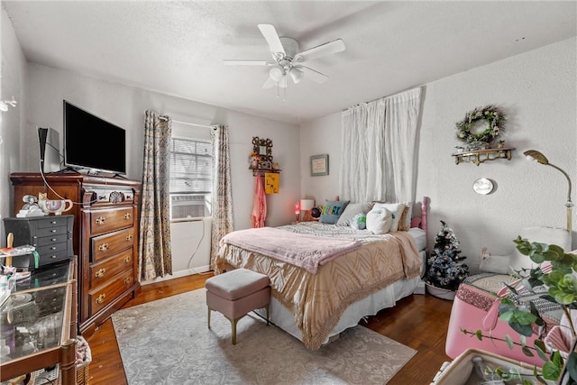 bedroom with a textured ceiling, dark wood-type flooring, and ceiling fan