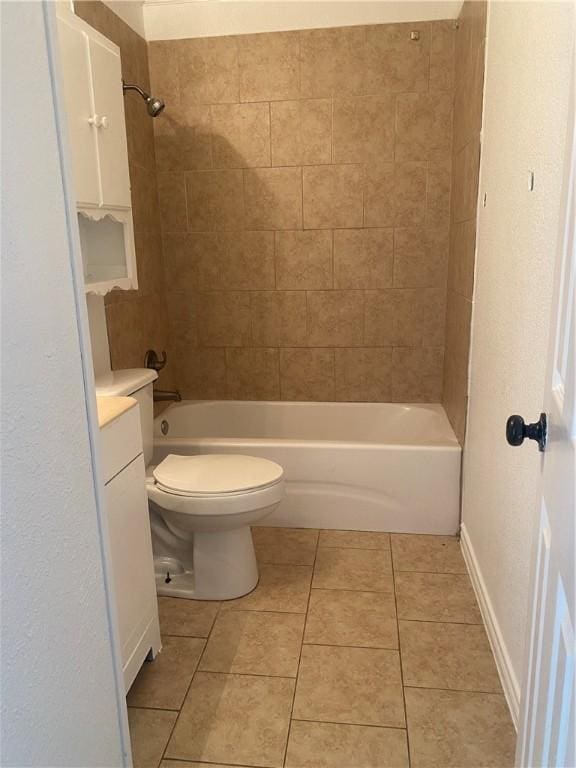 bathroom with tile patterned flooring, toilet, vanity, baseboards, and shower / washtub combination