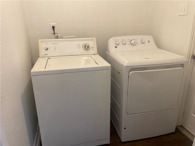 laundry room with laundry area, a textured wall, and washing machine and clothes dryer