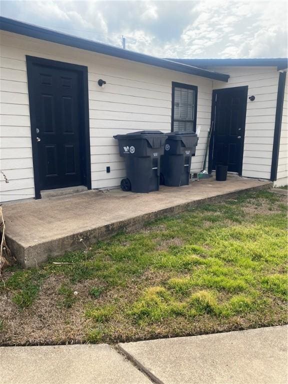 doorway to property with a lawn