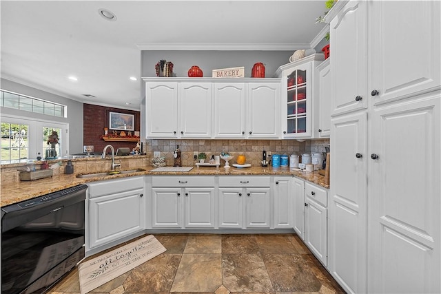 kitchen with light stone countertops, white cabinetry, sink, and french doors