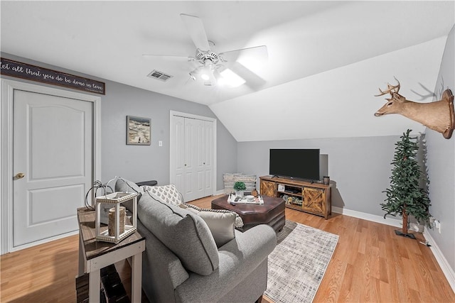 living room featuring ceiling fan, light hardwood / wood-style floors, and lofted ceiling