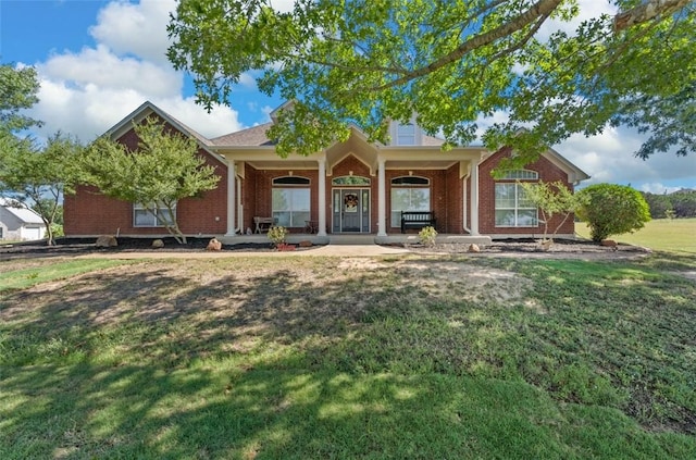 single story home featuring covered porch and a front lawn