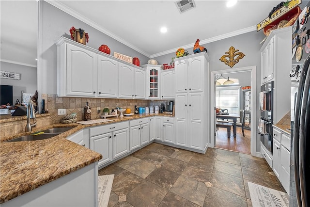 kitchen featuring white cabinetry, sink, light stone counters, and ornamental molding