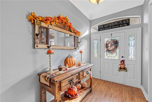 foyer entrance with light hardwood / wood-style flooring and ornamental molding