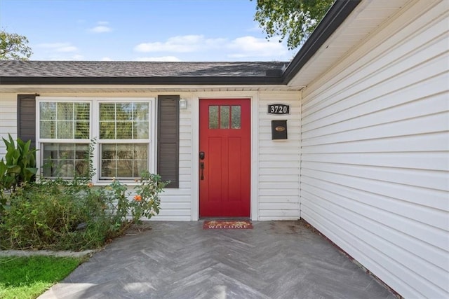 entrance to property with roof with shingles