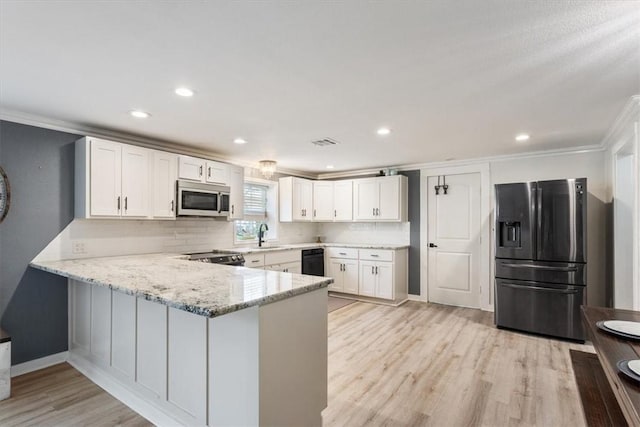 kitchen with visible vents, white cabinets, appliances with stainless steel finishes, a peninsula, and light stone countertops