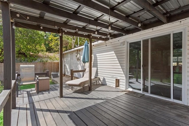 wooden deck featuring an outbuilding and fence