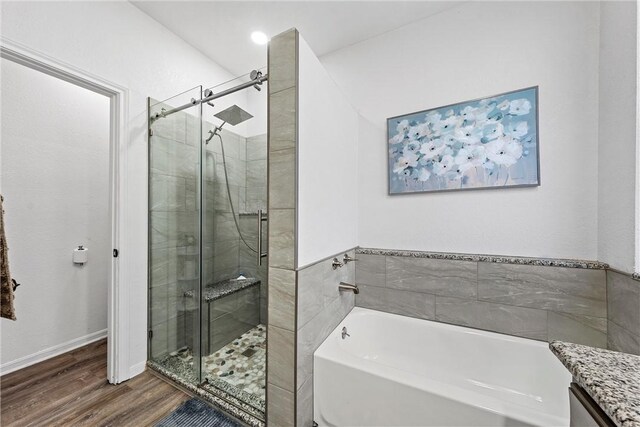 bathroom with separate shower and tub, vanity, and wood-type flooring