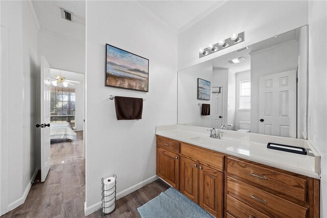 bathroom with hardwood / wood-style floors, toilet, ceiling fan, and a healthy amount of sunlight