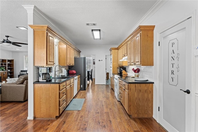 kitchen with a textured ceiling, hardwood / wood-style floors, white appliances, and sink