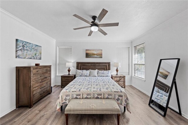 bedroom with light hardwood / wood-style floors, ceiling fan, and ornamental molding