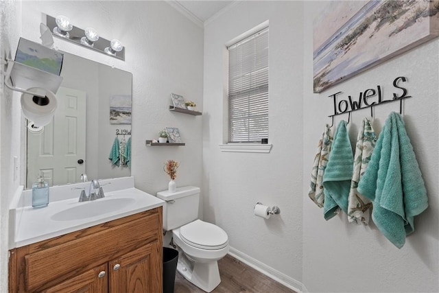 bathroom featuring crown molding, hardwood / wood-style floors, vanity, and toilet