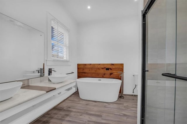 bathroom featuring hardwood / wood-style floors, vanity, and separate shower and tub