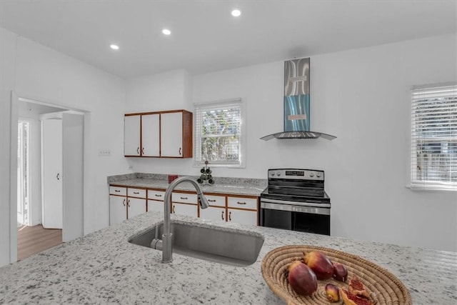 kitchen featuring stainless steel range with electric stovetop, extractor fan, sink, white cabinets, and light hardwood / wood-style floors