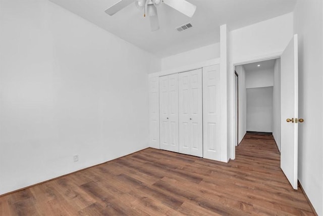 unfurnished bedroom with a closet, ceiling fan, and dark hardwood / wood-style flooring