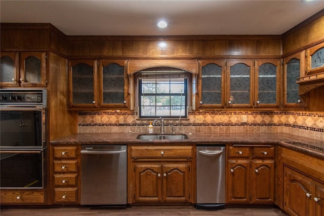 kitchen with dishwasher, sink, dark hardwood / wood-style floors, double oven, and tasteful backsplash