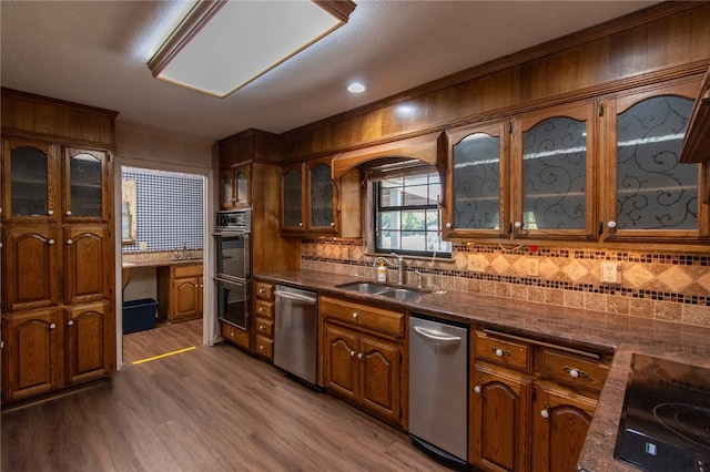 kitchen featuring dishwasher, sink, tasteful backsplash, dark hardwood / wood-style floors, and stovetop