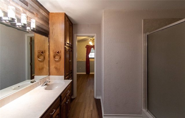 bathroom featuring hardwood / wood-style floors, vanity, and walk in shower