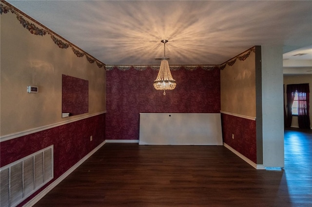 unfurnished dining area with dark wood-type flooring and a notable chandelier