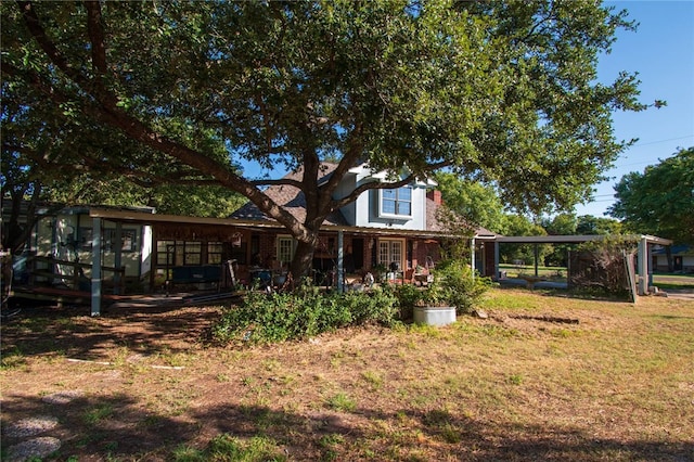 rear view of property featuring a lawn