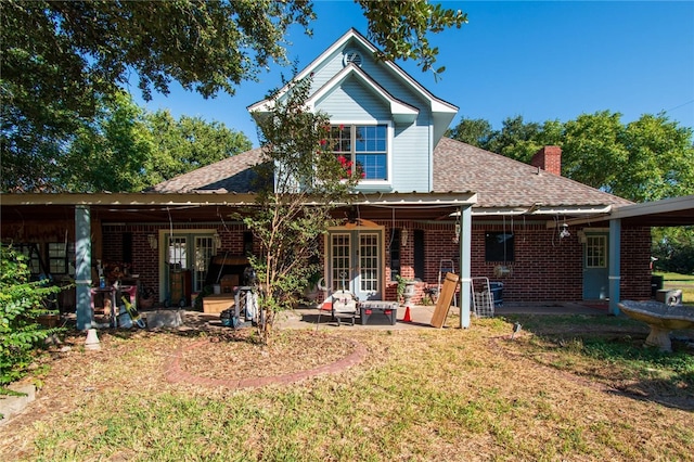 back of property with a lawn, a patio area, and french doors