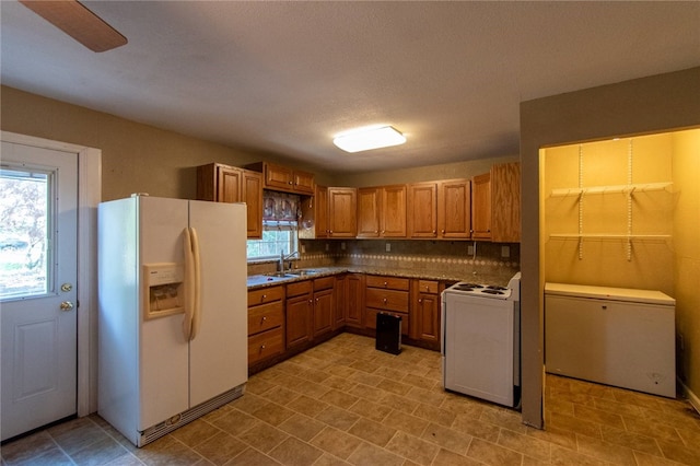 kitchen featuring a wealth of natural light, white fridge with ice dispenser, fridge, and washer / dryer