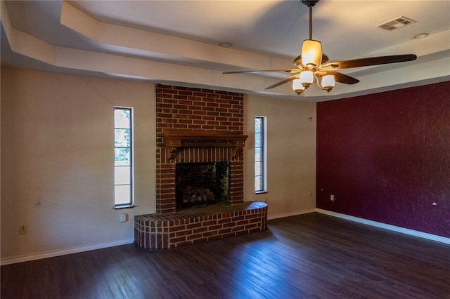 unfurnished living room with a fireplace, ceiling fan, and dark hardwood / wood-style flooring