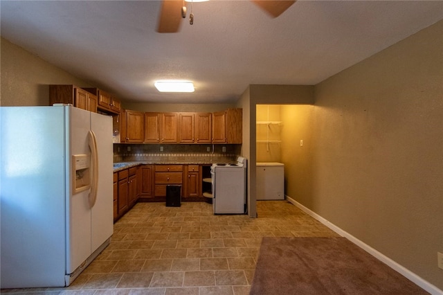 kitchen featuring ceiling fan, washer / dryer, white fridge with ice dispenser, and tasteful backsplash