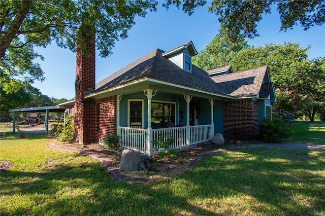 view of front of home with a front lawn, covered porch, and a carport