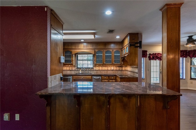 kitchen featuring kitchen peninsula, dark hardwood / wood-style flooring, and a healthy amount of sunlight