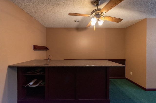 unfurnished office with ceiling fan, dark carpet, and a textured ceiling