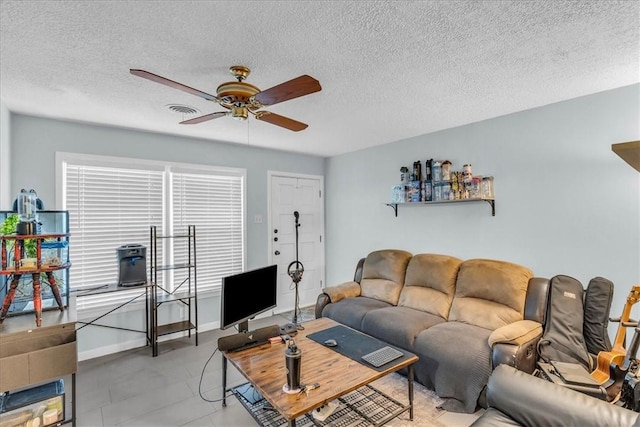 living room featuring ceiling fan and a textured ceiling