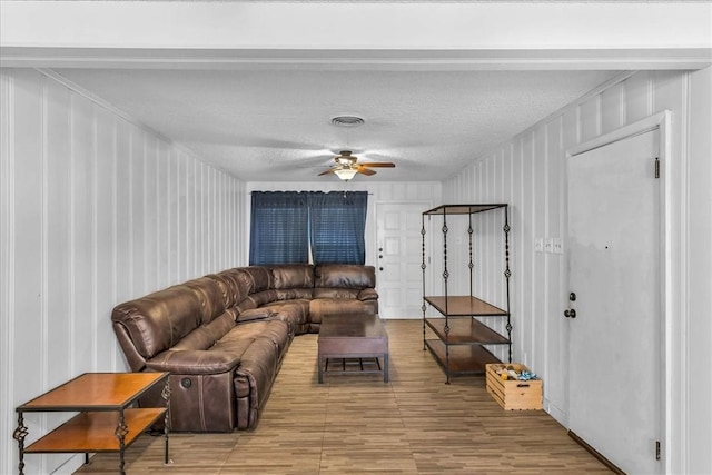 living room featuring a textured ceiling and ceiling fan