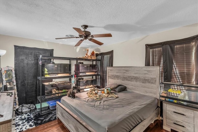 bedroom featuring a textured ceiling, dark hardwood / wood-style floors, and ceiling fan