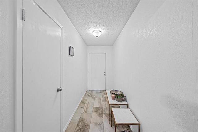 hall featuring a textured ceiling