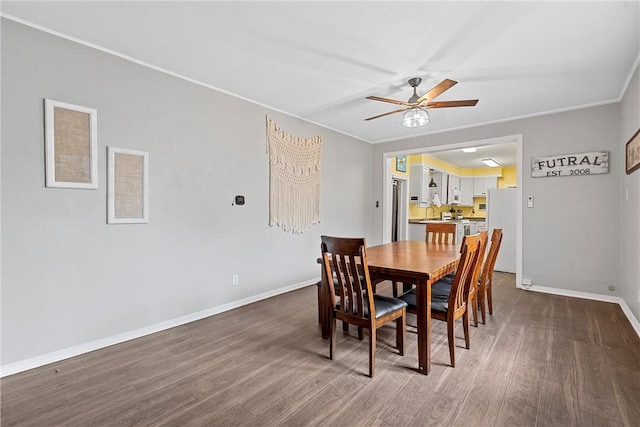 dining area featuring dark hardwood / wood-style flooring, ceiling fan, crown molding, and sink