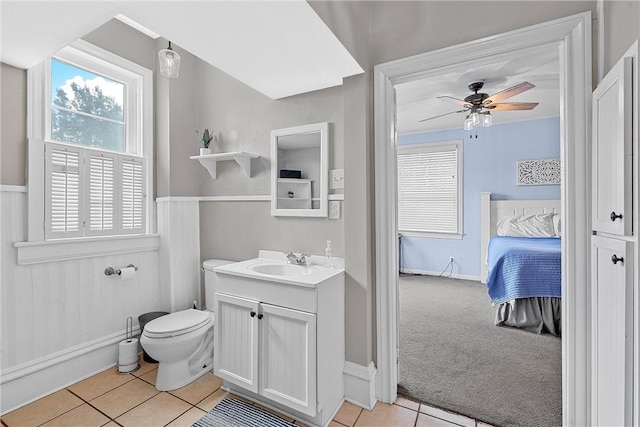 bathroom with tile patterned flooring, vanity, toilet, and ceiling fan