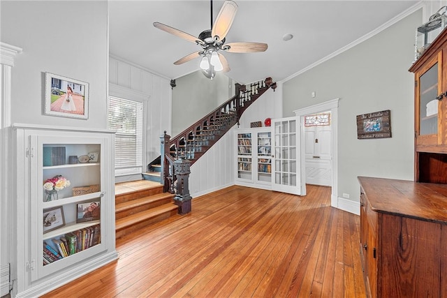 living room featuring wood-type flooring, ceiling fan, and crown molding