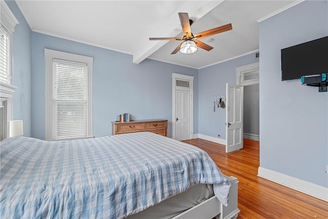 bedroom featuring ceiling fan, a fireplace, ornamental molding, and light wood-type flooring