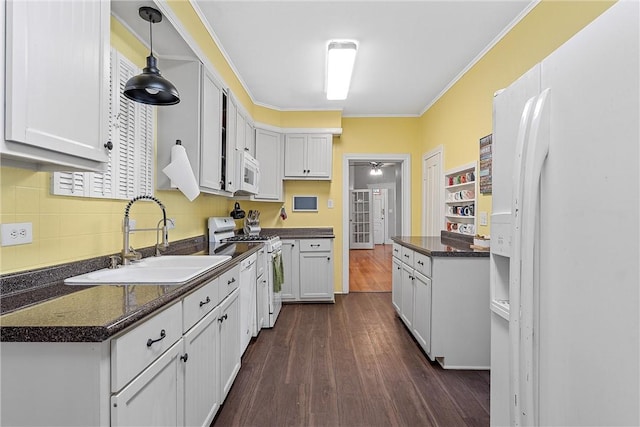 kitchen with dark hardwood / wood-style flooring, white appliances, sink, white cabinets, and hanging light fixtures