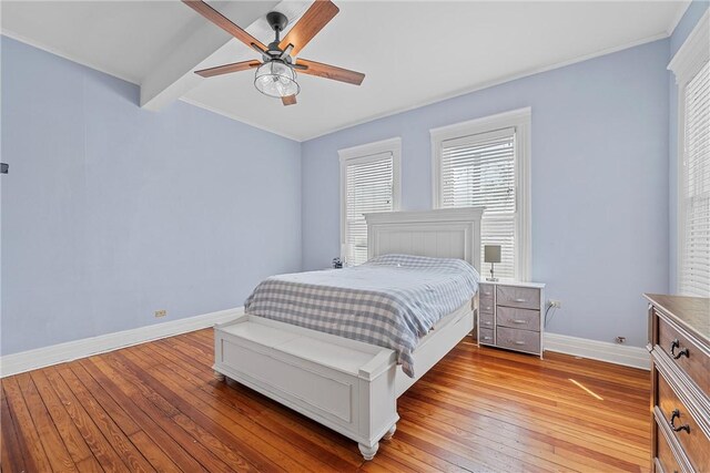 bedroom with beam ceiling, light hardwood / wood-style floors, and ceiling fan