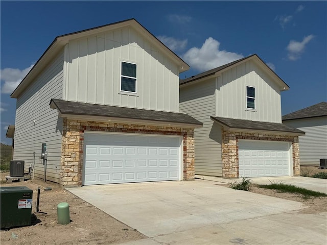 view of front of home with central AC unit and a garage